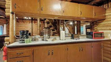 Una cucina in legno con piano di lavoro, pensili e una macchina per il caffè.