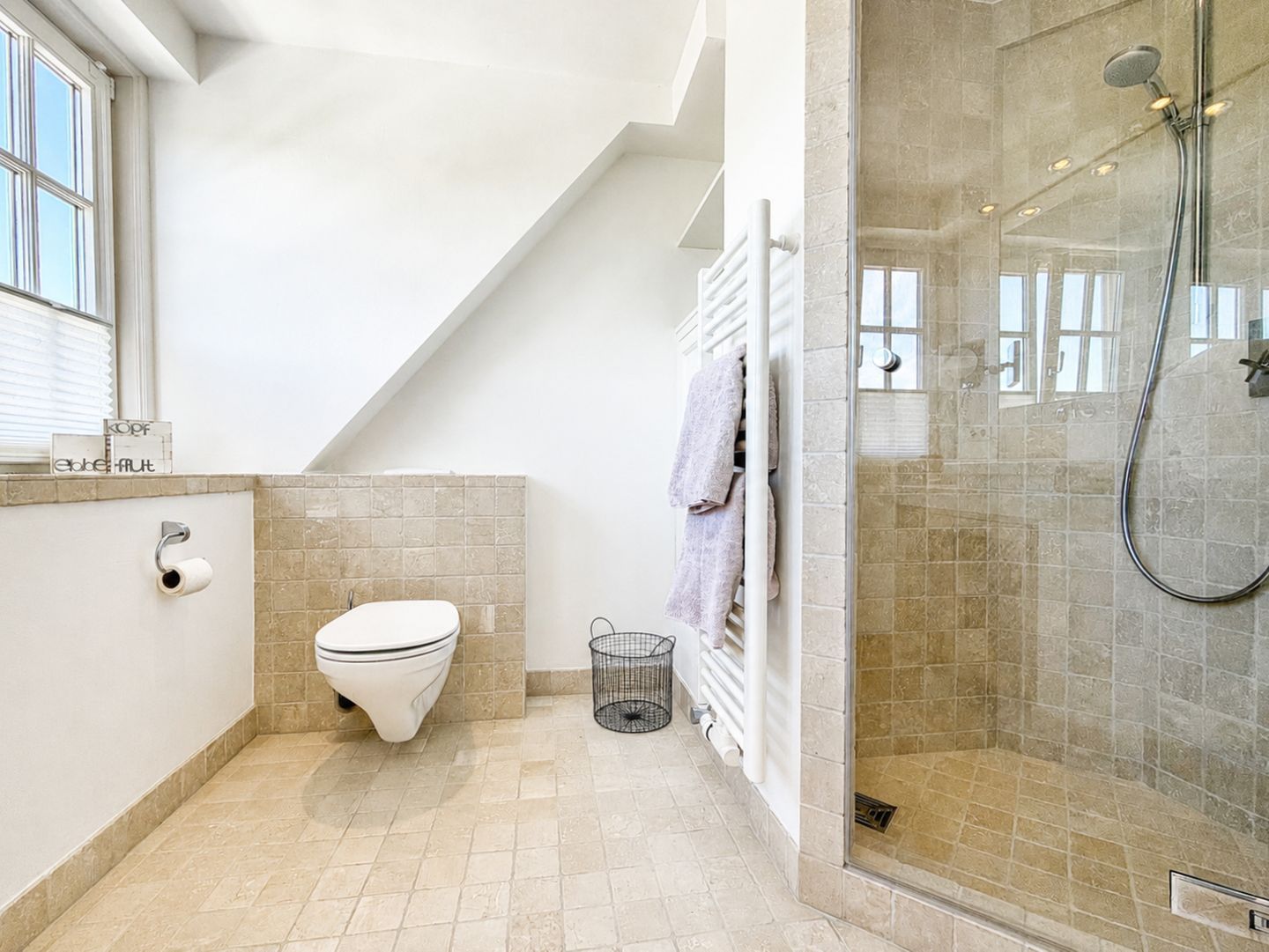 Ein modernes Badezimmer mit Toilette, Dusche und Handtuchhalter.