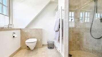 Ein modernes Badezimmer mit Toilette, Dusche und Handtuchhalter.