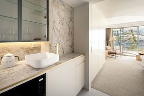 A modern bathroom with a white sink, marble backsplash, and a glass shower enclosure. - 
ForeverSunday Coastal© – Stay on the Golden Mile, right in the heart of Manly (Manly)