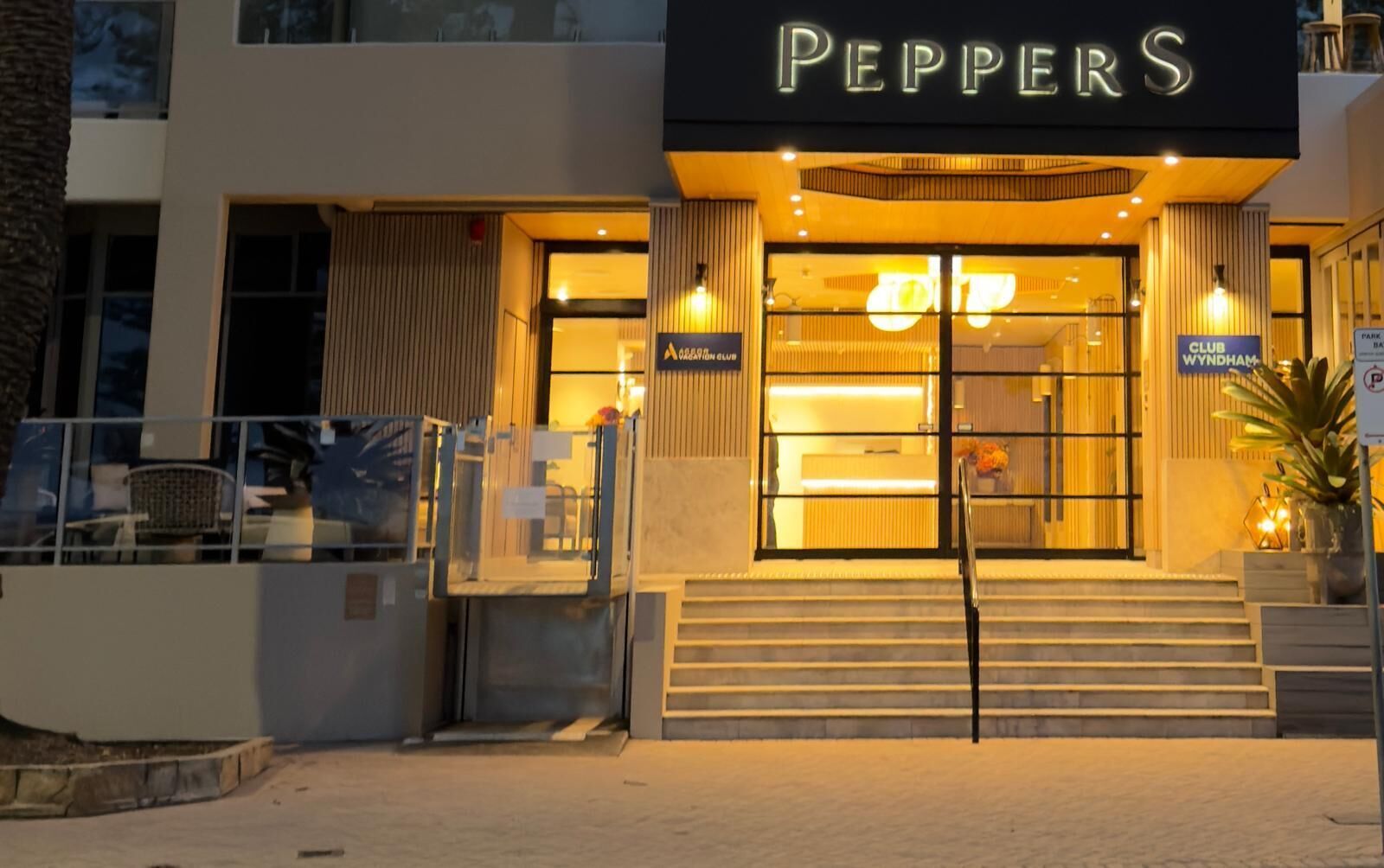 A building with a sign reading 'PEPPERS' and a 'GRILL' sign above the entrance.