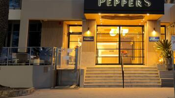 A building with a sign reading 'PEPPERS' and a 'GRILL' sign above the entrance.