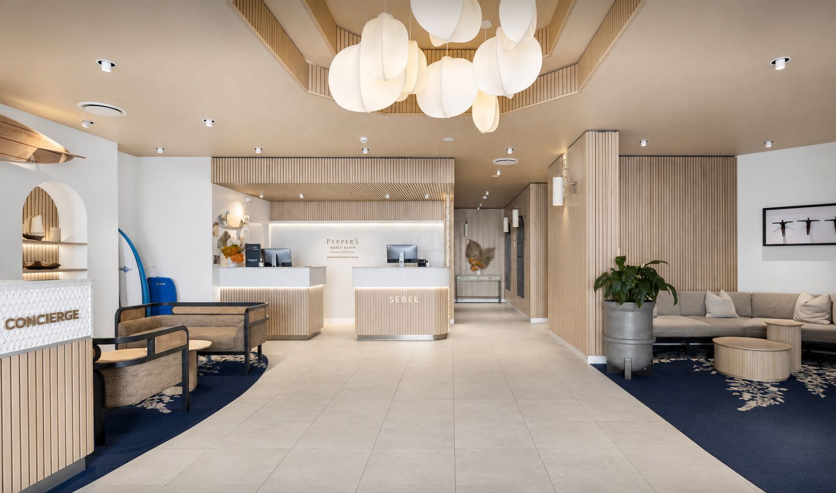 A modern hotel lobby with a reception desk, seating area, and a reception counter.