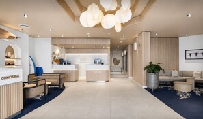 A modern hotel lobby with a reception desk, seating area, and a reception counter. - 
ForeverSunday Coastal* - Stay on the Golden Mile  - right in the heart of Manly (Manly)