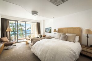 A hotel room with a large bed, a sofa, a chair, a table, and a view of the outdoors. - 
ForeverSunday Coastal* - Stay on the Golden Mile  - right in the heart of Manly (Manly)