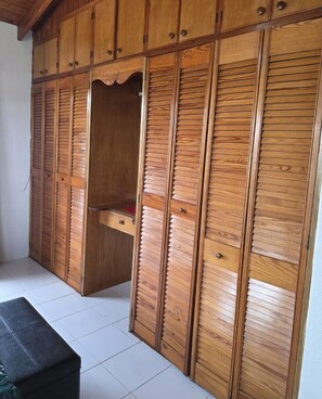 A room with a wooden wardrobe, a bench, and a tiled floor. - Spacious 2BR Home with Private Parking & Large Patio. (Frere Pilgrim)