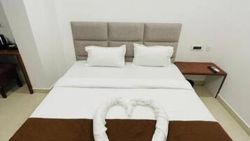 Una camera d'albergo con un letto, un comodino e un quadro appeso al muro.