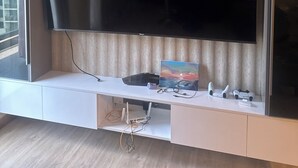 En platt-TV som är monterad på en vägg, med en träpanel som bakgrund.
