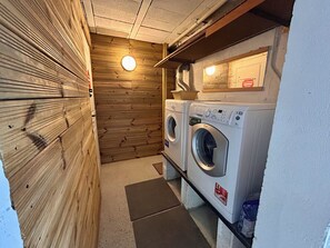A laundry room with two front-loading washing machines, a wooden wall, and a ceiling light. - Villa with a pool in the heart of Pyla-sur-Mer / La Teste-de-Buch / Arcachon (La Teste-de-Buch)