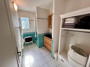 Een badkamer met een douche, toilet, wastafel en handdoekhouder.