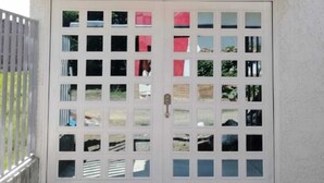 Ein weißes Gebäude mit einer großen Garagentür und einem Balkon mit weißer Brüstung.