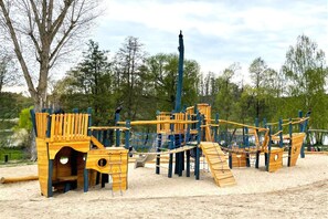 A playground with climbing structures and slides. - Moderner Doppelbungalow mit Terrasse und Grill im Ferienpark Mirow (Granzow)