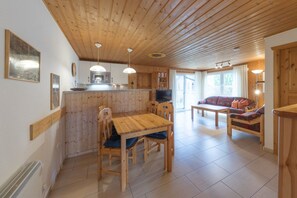 A wooden interior with a dining area, kitchen, and living space. - Doppelbungalow im skandinavischen Stil mit Terrasse im Ferienpark Mirow (Granzow)