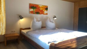 Une chambre à coucher avec un lit en bois, deux lampes de chevet, une table de chevet et un tableau accroché au mur.