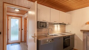 Eine moderne Küche mit Edelstahlgeräten, Holzböden und einer Holzzielende.
