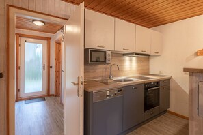 Eine moderne Küche mit Edelstahlgeräten, Holzböden und einer Holzzielende.