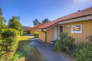 A single-story building with a red-tiled roof, a visible window, and a sign indicating the number 153. - Gemütlicher Doppelbungalow im Ferienpark Mirow mit Terrasse (Granzow)
