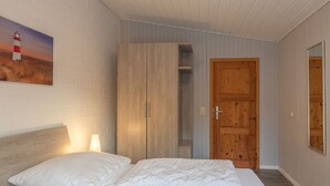 Ein Schlafzimmer mit einem Bett, einem Kleiderschrank und einer Tür.