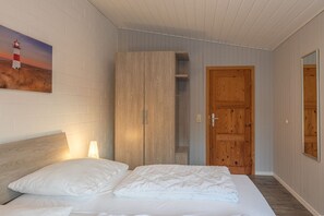 Ein Schlafzimmer mit einem Bett, einem Kleiderschrank und einer Tür.