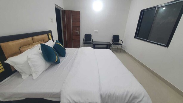 Een hotelkamer met een bed, een kledingkast, een bureau en een stoel.