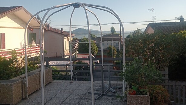 Ein Pavillon mit Metallgestell und Kiesboden.