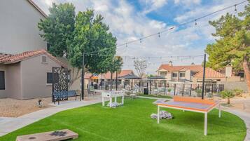 A residential area with a well-maintained lawn, outdoor seating, and a pool area.