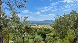 A view of a countryside landscape with olive trees and a distant mountain range. - Les 4 Sources / Apartment with a view, terrace, air conditioning, and private parking (Villelaure)