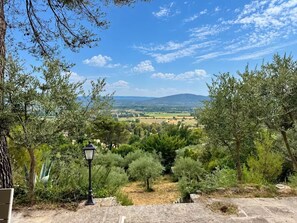 A view of a countryside landscape with olive trees and a distant mountain range. - Les 4 Sources / Apartment with a view, terrace, air conditioning, and private parking (Villelaure)