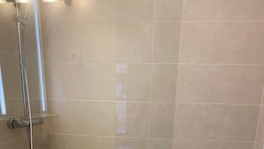 Um banheiro com chuveiro, pia e vaso sanitário.