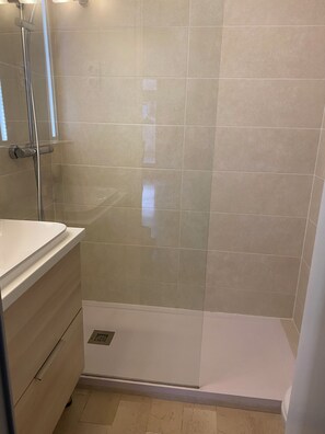 Ein Badezimmer mit Dusche, Waschbecken und Toilette.
