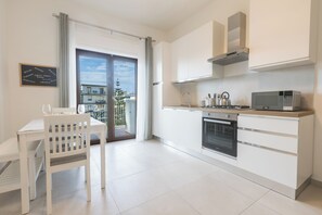 A modern kitchen with white cabinetry, a built-in oven, and a microwave. - ErKaNi Dimora Sorrento – Contemporary 1-Bedroom Apartment in Downtown Sorrento (Sorrento)