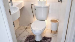 A bathroom with a toilet, sink, and shower. - S&G Beachfront Serviced 1-br, Step to Tops and 7-11 (Pattaya)