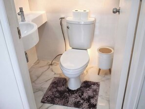 A bathroom with a toilet, sink, and shower. - S&G Beachfront Serviced 1-br, Step to Tops and 7-11 (Pattaya)