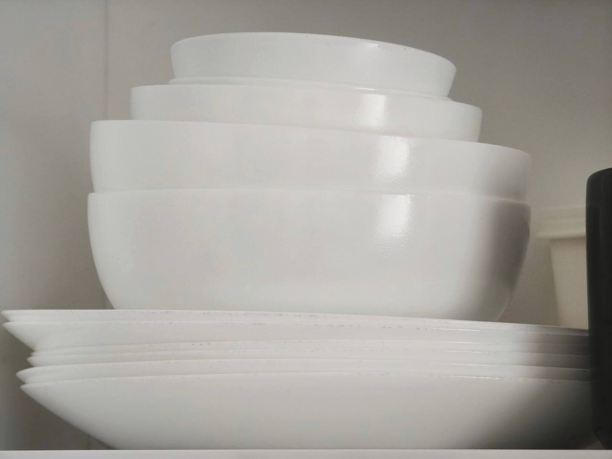 Une pile de bols blancs sur une surface blanche.