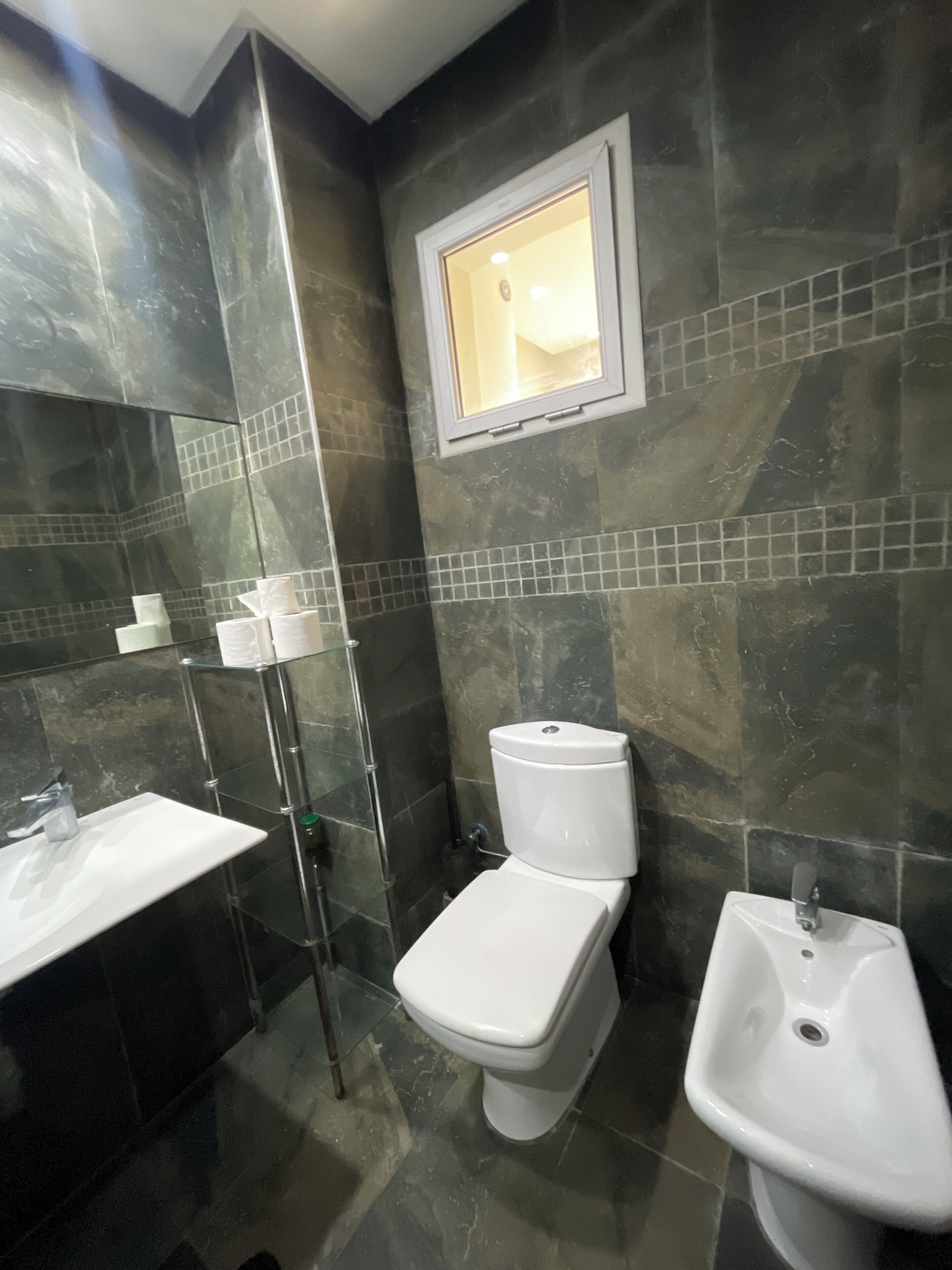 A bathroom with a toilet, bidet, and sink.