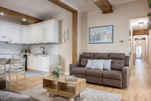 A living room with a sofa, coffee table, and a painting of a cityscape. - The Blue Lily by Maison Florence  (Firenze)