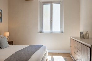 A bedroom with a bed, a window, a nightstand, a dresser, and a lamp. - The Blue Lily by Maison Florence  (Firenze)