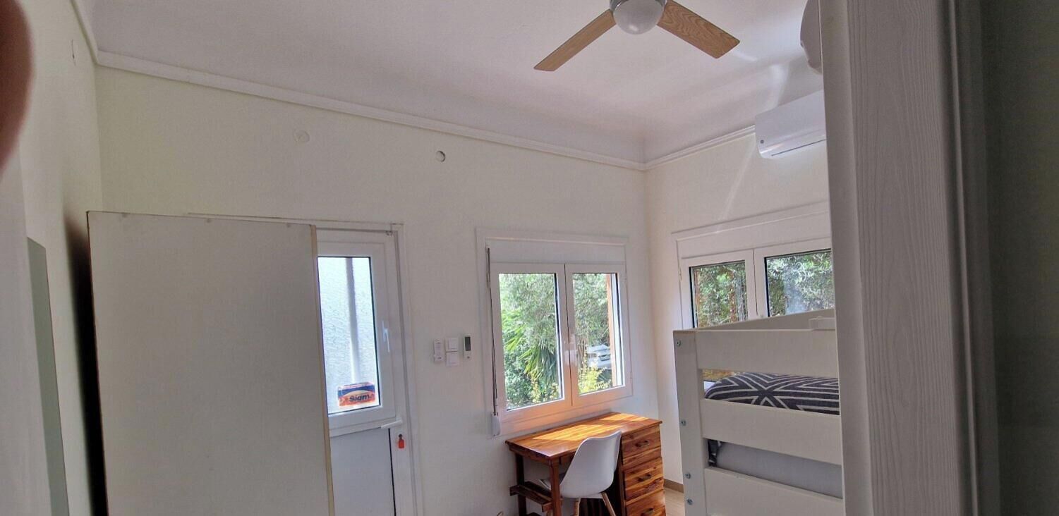 A room with a bed, a desk, and a window.