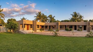 Un hôtel moderne doté d’un toit plat, de nombreuses chambres et d’une cour intérieure agrémentée de palmiers.