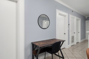 A hallway with a wooden desk, a black chair, and a round mirror on the wall. - The C2 Gateway to Starbase (Brownsville)