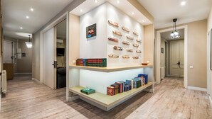 A hallway with a built-in bookshelf displaying books and decorative signs. - Modern, spacious monthly rental (min 32 nights) in the city centre. (Barcelona)