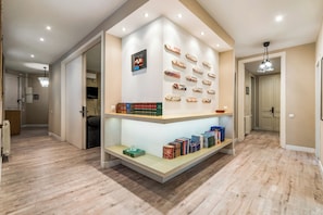 Ein Flur mit einer eingebauten Bücherwand, auf der Bücher und dekorative Schilder stehen.