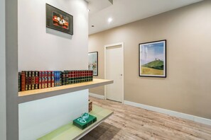 A hallway with a bookshelf, a framed picture, and a door. - Modern, spacious monthly rental (min 32 nights) in the city centre. (Barcelona)