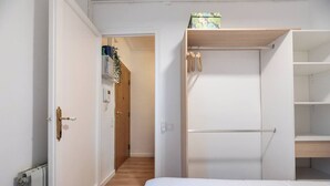Ein Schlafzimmer mit einem Bett, einem Kleiderschrank und einer kleinen Ablage mit einer Kiste.
