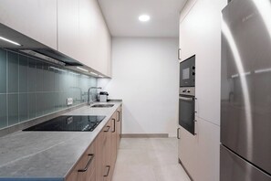 Eine moderne Küche mit Einbauherd, Backofen und Mikrowelle.