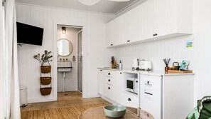 Eine moderne Küche mit weißen Schränken, einem eingebauten Ofen und einer Mikrowelle.
