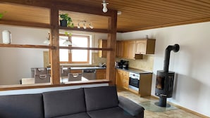 Una cocina moderna con armarios de madera, una estufa y una zona de comedor con sofá.