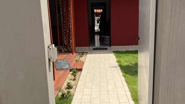A pathway leading to a building with a red facade and a tiled roof. - Cité Italia - Quiet & elegant villa with garden/terrace - near the beaches (Modest)