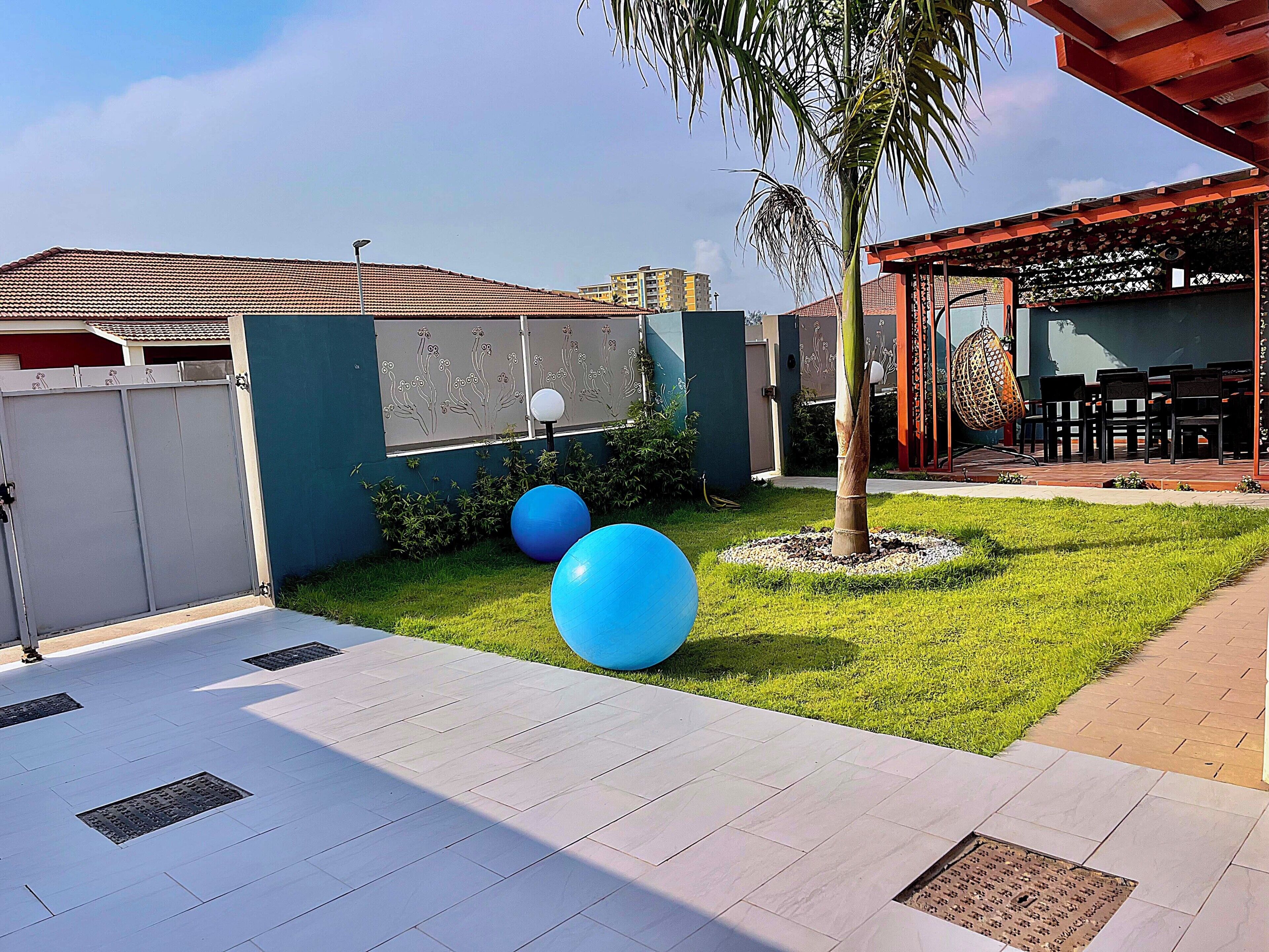 A courtyard with a tiled patio, a palm tree, and outdoor seating.