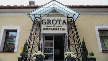 A building with a sign reading 'GROTA RESTAURACJA' and a triangular metal structure above the entrance.
